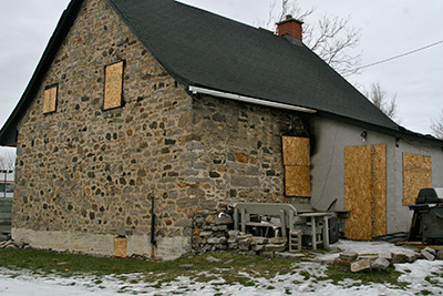 Le long du chemin Côte-de-Liesse entre MacNeil et Saint-Clare se trouve une très vieille maison de ferme en pierre de 1840. Ses murs de pierre sont partiellement recouverts d’un crépi de ciment du côté est, ce qui laisse croire que la pierre naturelle apparente l’était peut-être aussi à l’origine. (Archives Ville Mont-Royal)